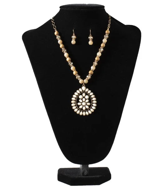 Jewelry set with necklace and earrings made of natural wooden beads with a white stone pendant, on a black bust