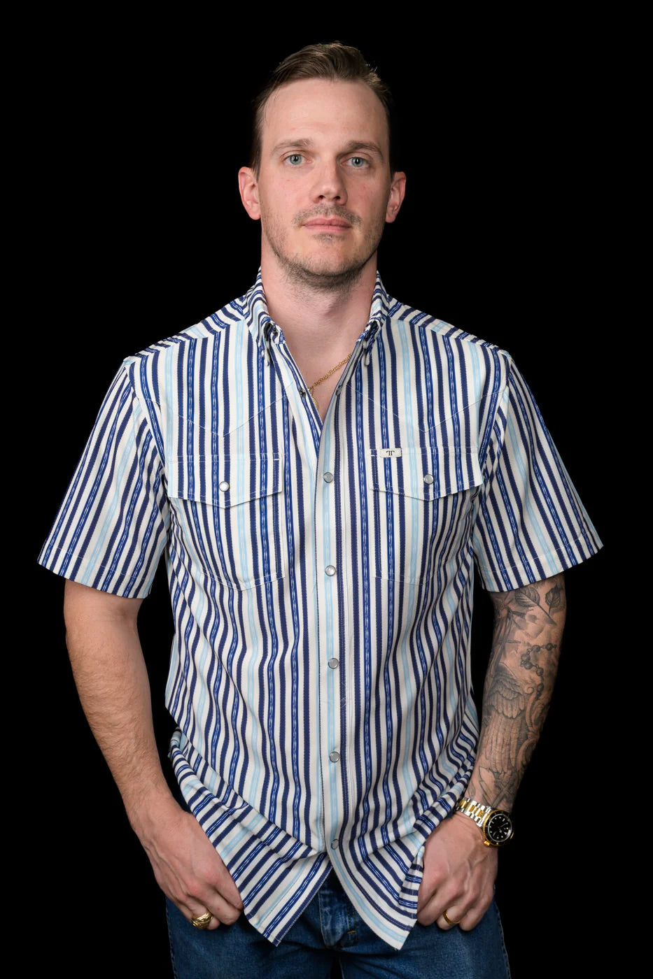 Man wearing a Ferrell Brand blue and white striped shirt against a black background
