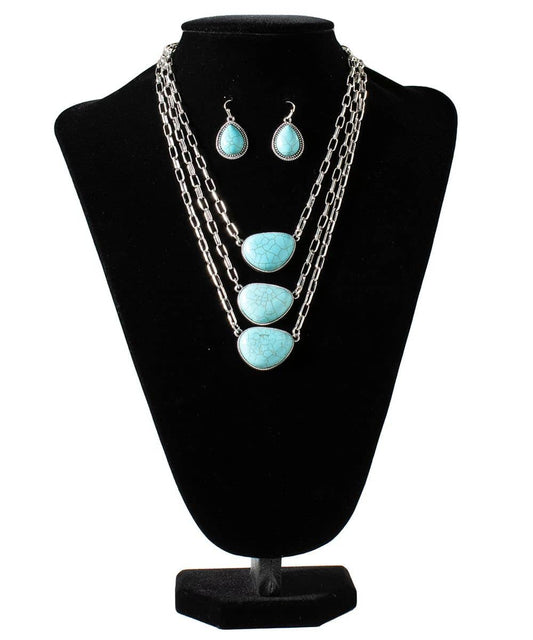 Turquoise necklace and earrings set on a black bust