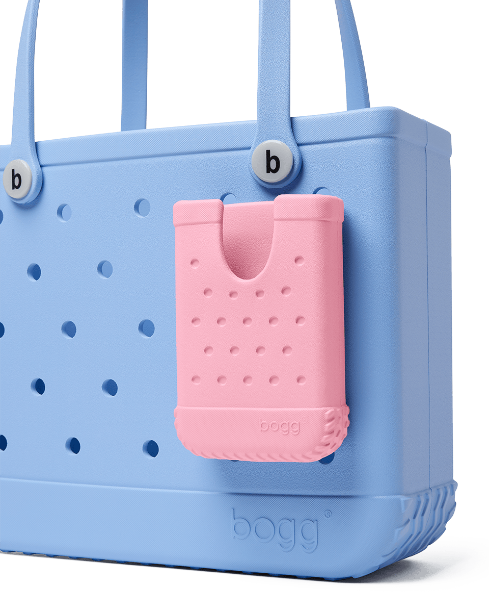 Blue Bogg bag with pink phone case attached, on a white background