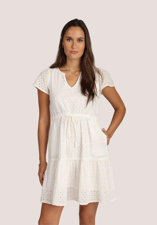 Woman wearing a white dress with a plain background