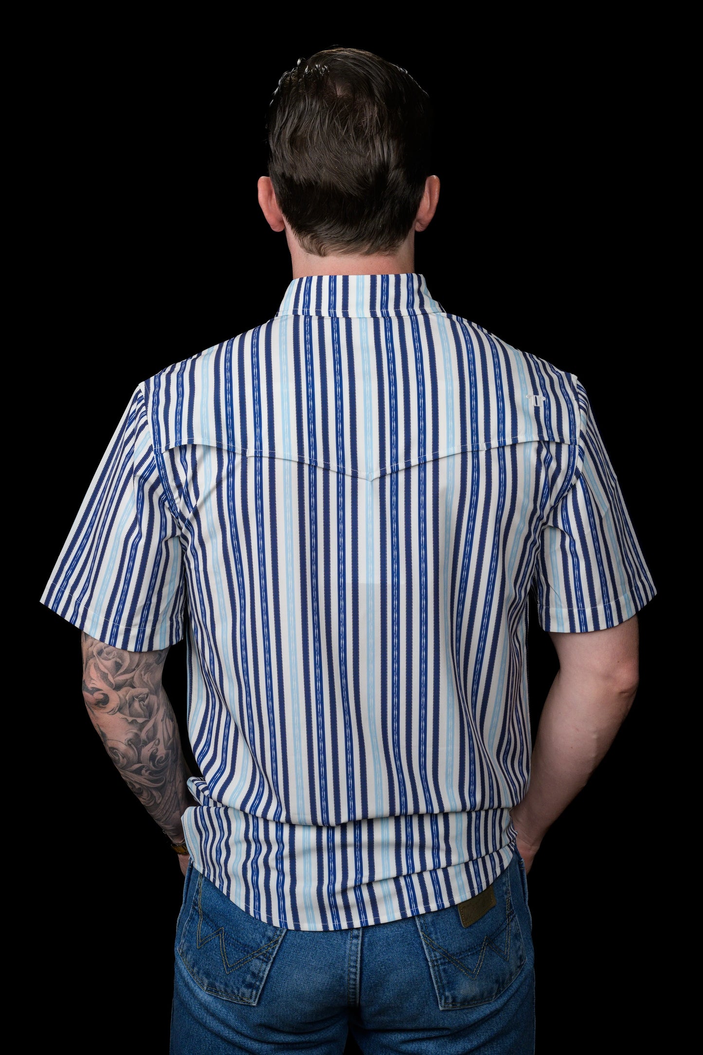 Back view of person wearing a Ferrell Brand blue and white striped shirt with a black background