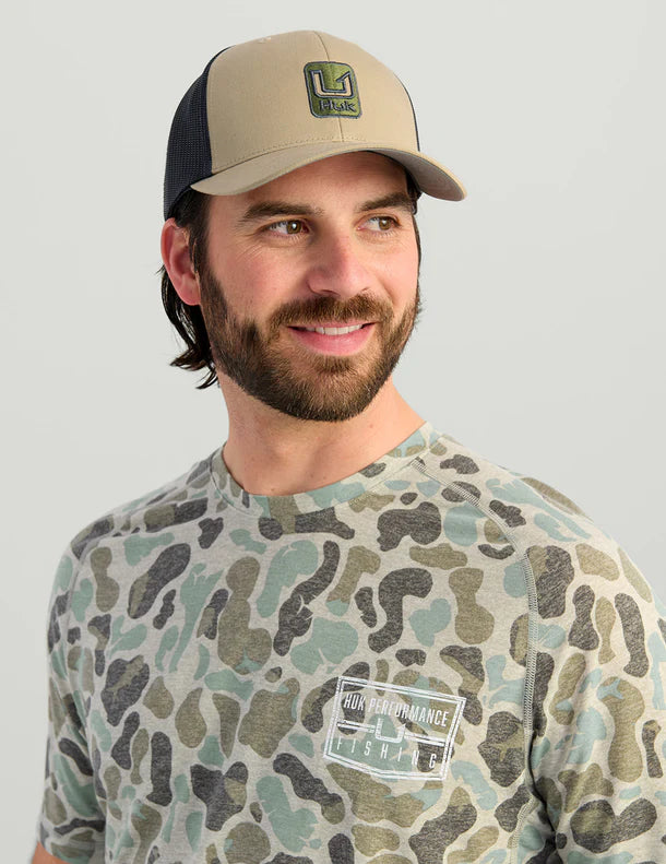 Huk Stacked U Trucker Hat in Overland