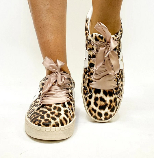 Leopard print sneakers with pink ribbons on a white background