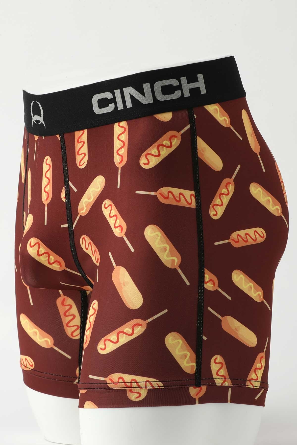 Side view of male mannequin bottom wearing burgundy boxer briefs with corndog print on white background