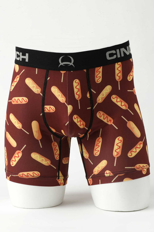 Male mannequin bottom wearing burgundy boxer briefs with corndog print on white background
