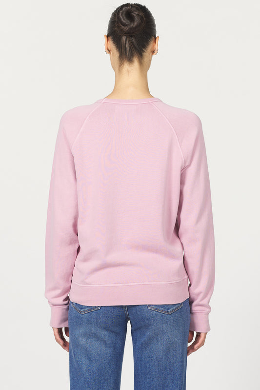 Back view of a person wearing a pink sweatshirt and blue jeans on a white background
