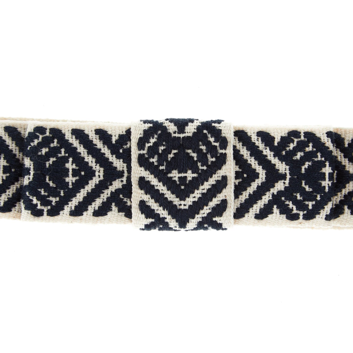 Closeup view of a navy, white, and arrow patterned hatband on a white background