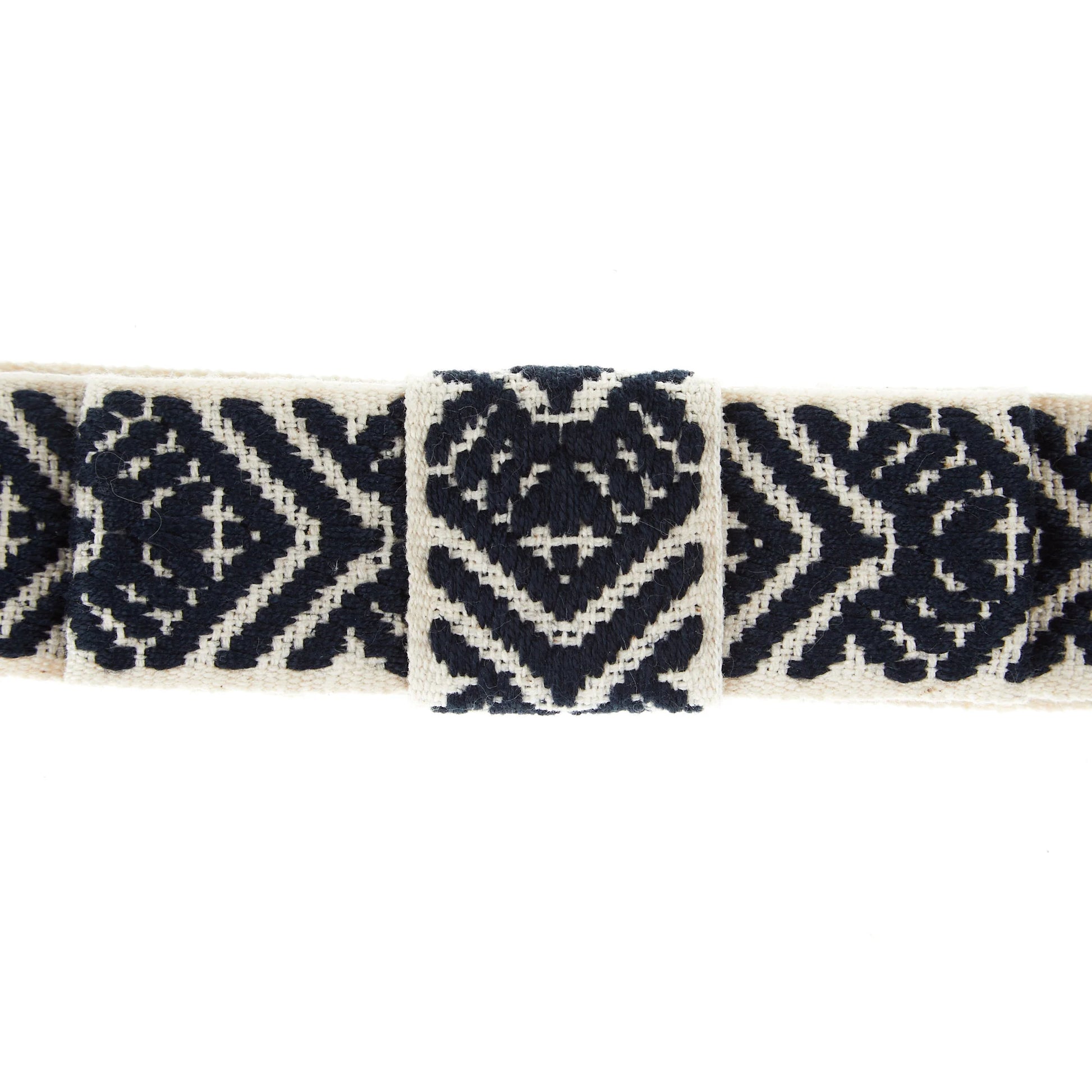 Closeup view of a navy, white, and arrow patterned hatband on a white background