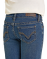 Blue jeans with a brand logo on the back pocket against a white background