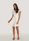 Woman wearing a white dress on a plain background