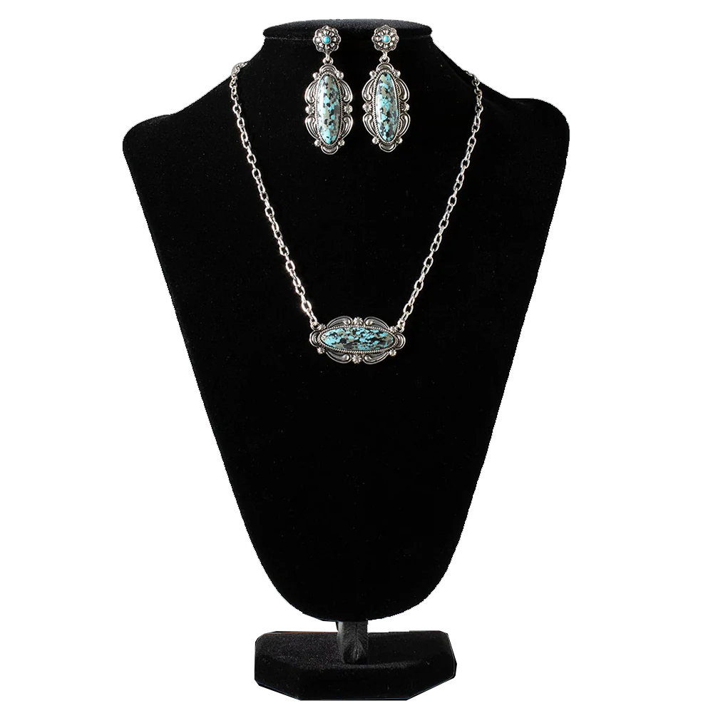Silver and turquoise jewelry set with necklace and earrings on a black bust